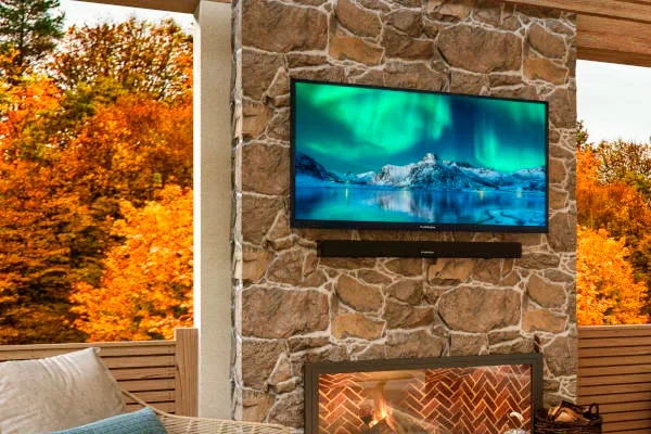 Outdoor TV mounted on stone wall in the fall