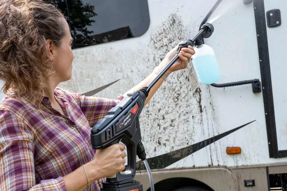 Woman washing RV with pressure washer