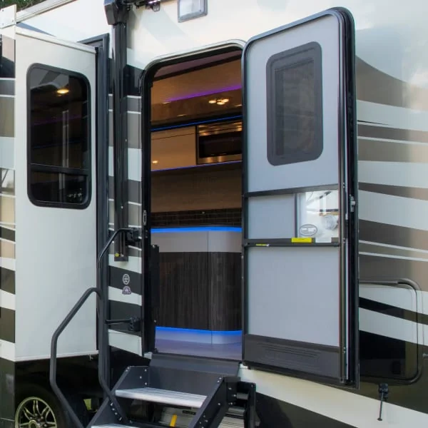 Open RV entry door with screen door and steps