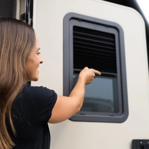 Person opening Thin Shade window kit on RV entry door