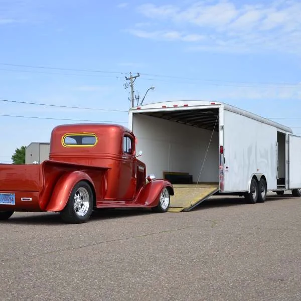 Truck being loaded on enclosed tandem axle trailer
