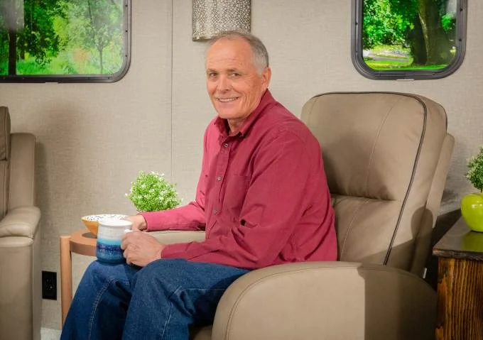 Man enjoying a cup of coffee in an RV swivel recliner