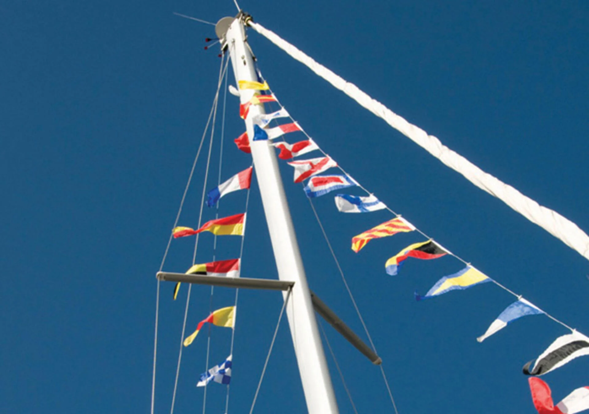 Nautical Flags Hanging from Mast of Boat