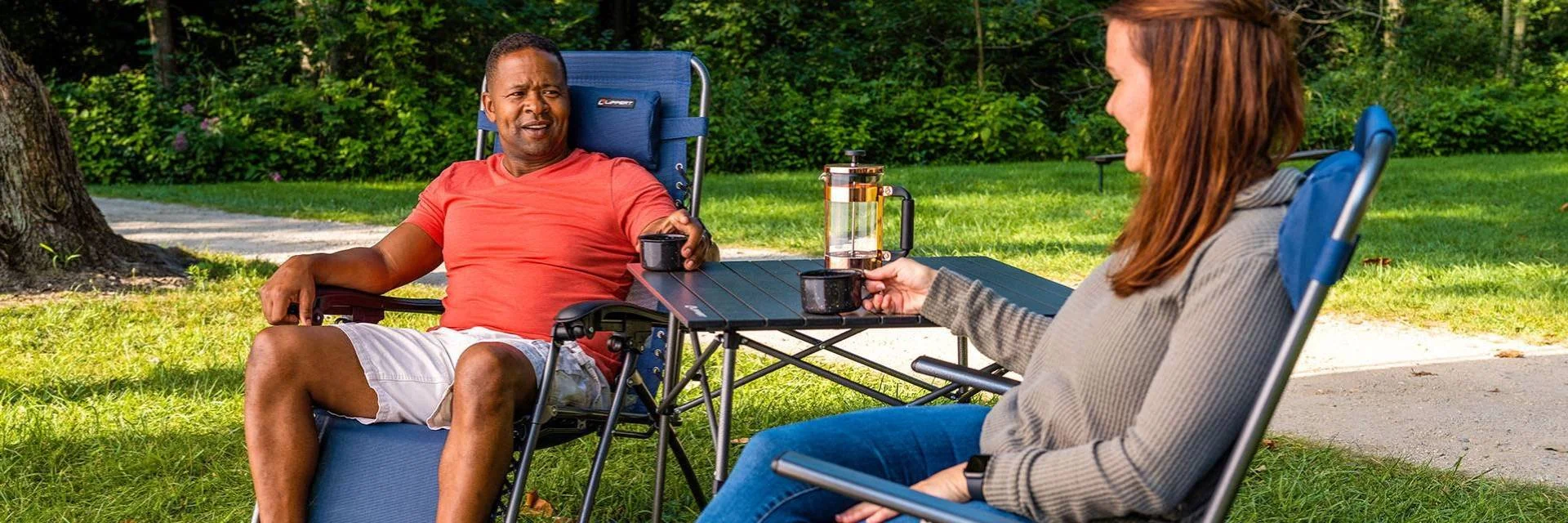 Two People in Sitting on Outdoor Furniture and Drinking Coffee on Outdoor Table