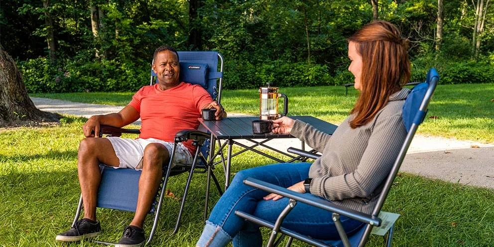 Two People in Sitting on Outdoor Furniture and Drinking Coffee on Outdoor Table