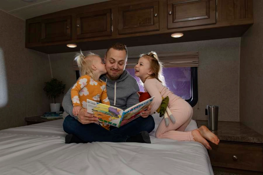Father reading to his children on an RV mattress