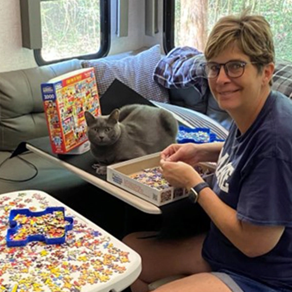 D&rsquo;Anne Terrill putting together a puzzle with her cat Boomer