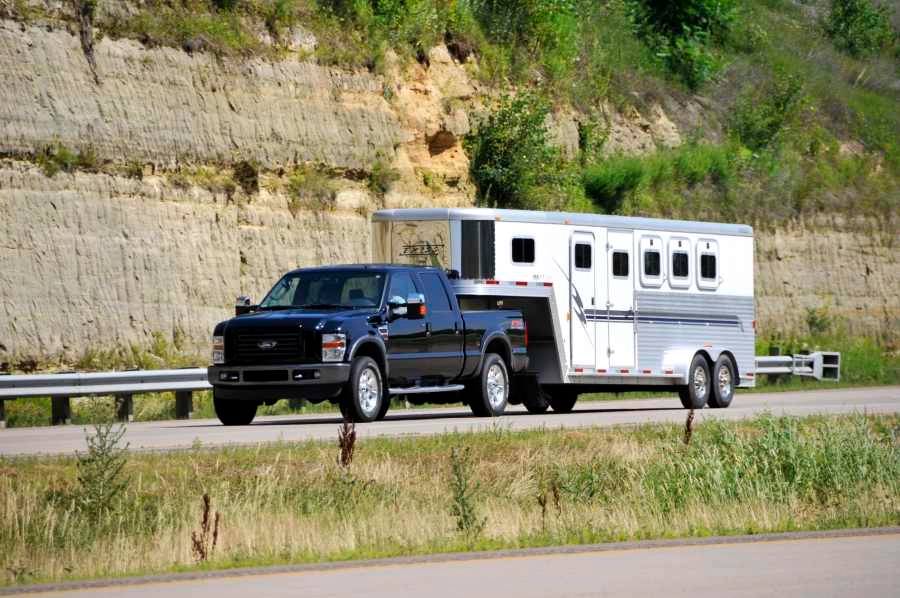 Truck driving down the highway hauling cargo with a gooseneck hitch